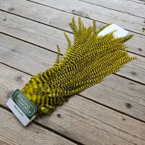Green feather duster on a wooden surface with a brand tag.